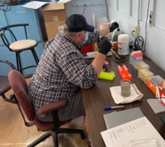 A wastewater technician preparing a wastewater sample for PCR testing after training with University of Kentucky lab technicians